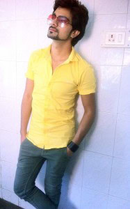 He's dressed in jeans and a yellow shirt.